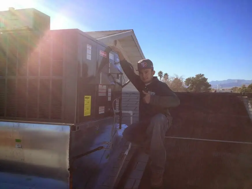 HVAC technician performing AC Tune-Up on a rooftop unit in Richmond Heights